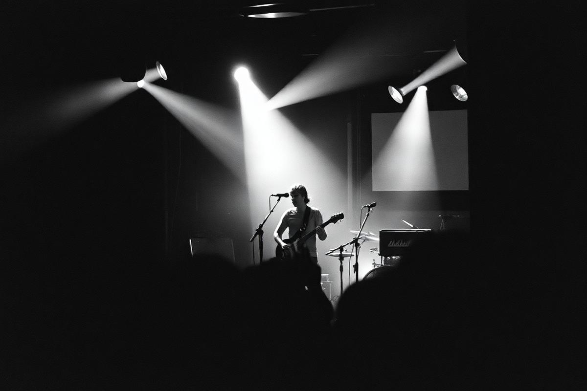 Band on a club stage under hard backlight